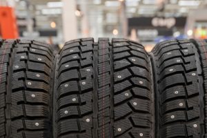 winter studded rubber, wheel, front view. photo with a shop in the background